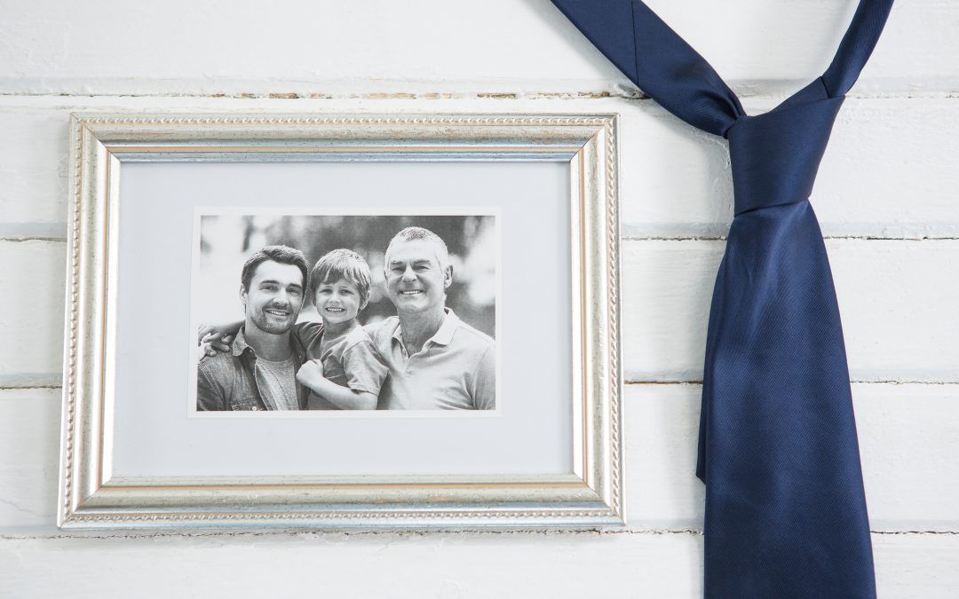 Cadre photo familial accompagné d’une cravate, illustrant les objets symboliques utilisés lors d’un hommage funérair